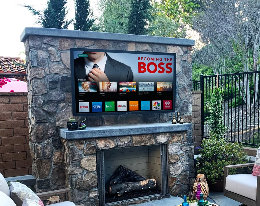 An outdoor rated television mounted to a store fireplace